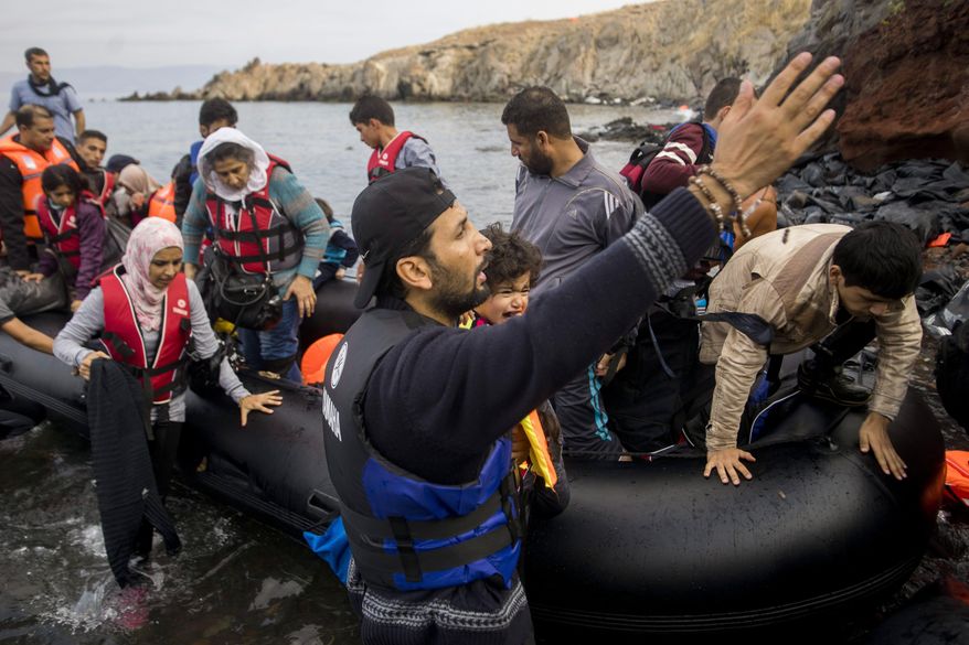 Migrants arrive with an overloaded rubber dinghy from Turkey on the coast of Lesbos island, Greece, Tuesday, Oct. 6, 2015. (Zoltan Balogh/MTI via AP)