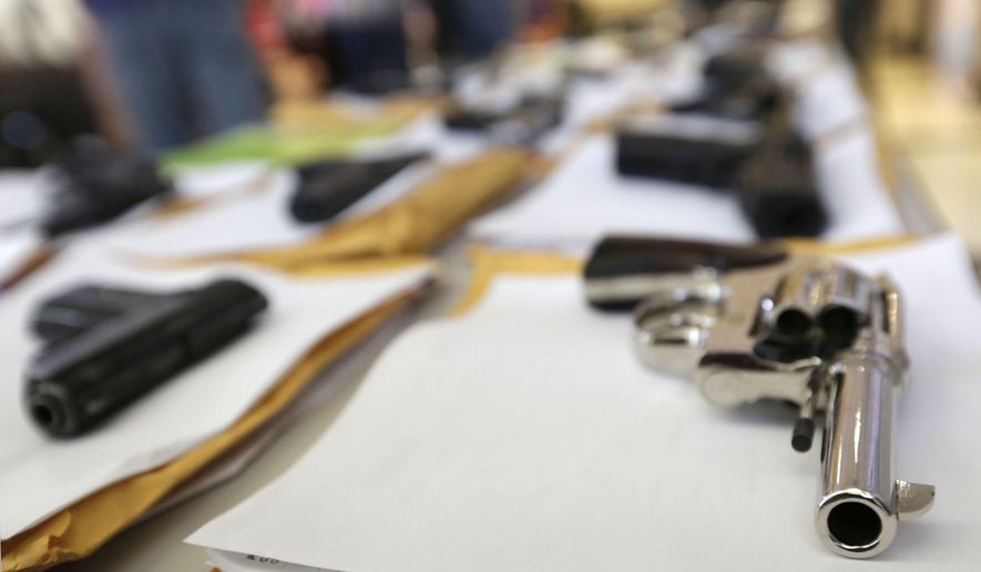 FILE - In this Monday, July 7, 2014, file photo, Chicago police display some of the thousands of illegal firearms they have confiscated so far this year in their battle against gun violence in Chicago. The recent mass shooting at an Oregon community college has put the debate over gun violence and gun control into the center of the presidential race. At least some of the Republicans who are running have pointed to Chicago as proof that gun control laws don't work. (AP Photo/M. Spencer Green)