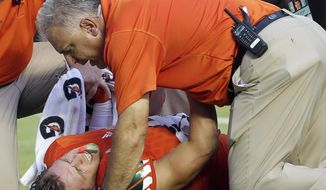 FILE - In this Sept. 2, 2015, file photo, Miami wide receiver Braxton Berrios (8) grimaces in pain after an injury in the first half of an NCAA college football game against Bethune Cookman in Miami Gardens, Fla. ACC Commissioner John Swofford embraced an NCAA proposal and implemented a league-wide policy that ACC teams would be required to assign a medical observer selected by each respective school for every game _ home, away, and at neutral sites. (AP Photo/Alan Diaz, File)