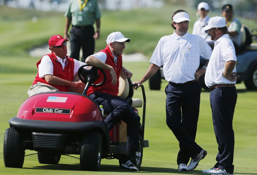 United States' J.B. Holmes, right and teammate Bubba Watson talk with team assistants Davis Love III, left, and Steve Stricker during their foursome match at the Presidents Cup golf tournament at the Jack Nicklaus Golf Club Korea, in Incheon, South Korea, Thursday, Oct. 8, 2015.(AP Photo/Woohae Cho)