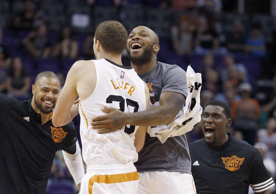 Phoenix Suns' Jon Leuer, second from left, celebrates his dunk against the Sacramento Kings with teammates Tyson Chandler, left, Kyle Casey, right, and P.J. Tucker during the first half of an NBA preseason basketball game Wednesday, Oct. 7, 2015, in Phoenix. (AP Photo/Ross D. Franklin)