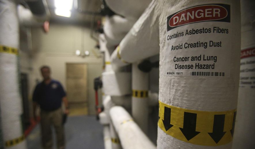 In this photo taken on Oct. 2, 2015, a sign warning of asbestos is displayed on a pipe of the engineering room at the John H. Wood, Jr. Federal Courthouse, in San Antonio, Texas. (John Davenport /The San Antonio Express-News via AP)