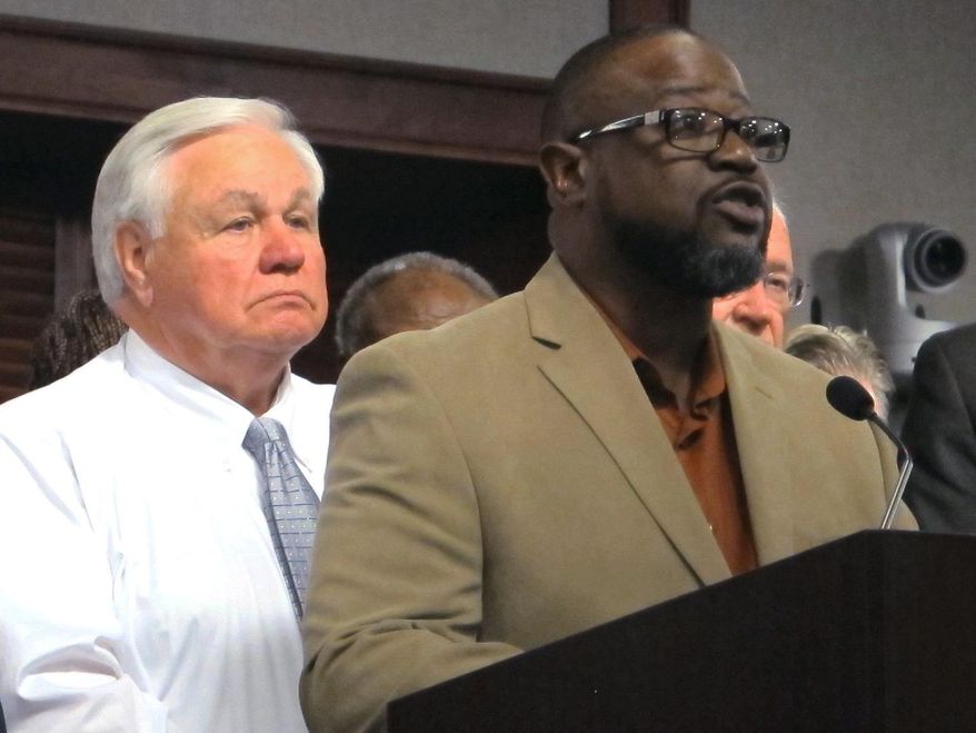 Anthony Scott, the brother of Walter Scott, the unarmed black motorist who was shot and killed by a North Charleston, S.C., police officer earlier this year, speaks Thursday, Oct. 8, 2015, in North Charleston after the city council approved a $6.5 million settlement with the Scott family. North Charleston Mayor Keith Summey is at left. (AP Photo/Bruce Smith)