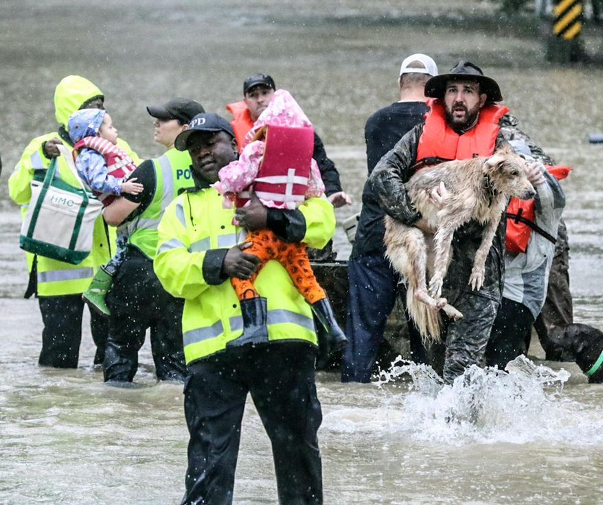 In this photo taken on Sunday, Oct. 4, 2015, Columbia Police rescue children and families from the floodwater on Lakewood Drive in Forest Acres, S.C. (Matt Walsh /The State via AP) ALL LOCAL MEDIA OUT, (TV, ONLINE, PRINT); MANDATORY CREDIT