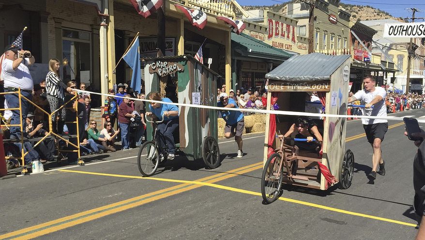 ADVANCE FOR SATURDAY OCT. 10 AND THEREAFTER - In this Oct. 3, 2015 photo, riders compete in the 26th Annual World Championship Outhouse Races in Virginia City, Nev. Twenty-six teams of three built mobile outhouses on wheels to race across a finish line made of toilet paper, all the while imbibing and enjoying the historic flair for which the town is known. (Seth A. Richardson/Reno Gazette Journal via AP) NO SALES; NEVADA APPEAL OUT; SOUTH RENO WEEKLY OUT