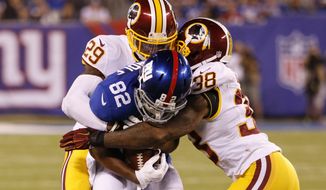 New York Giants&#x27; Rueben Randle (82) is tackled by Washington Redskins&#x27; Dashon Goldson (38) and Chris Culliver (29) during the second half an NFL football game Thursday, Sept. 24, 2015, in East Rutherford, N.J. (AP Photo/Kathy Willens)
