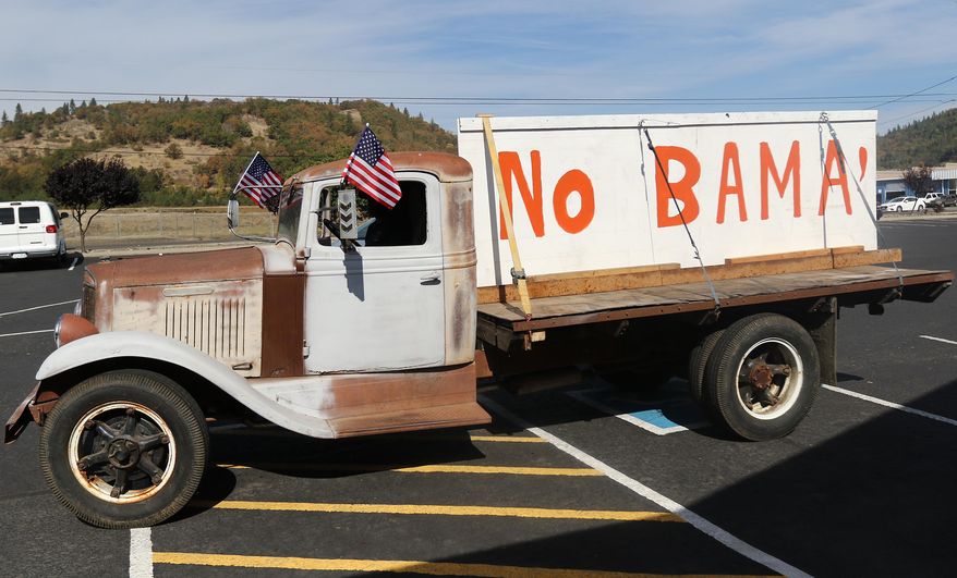 Gary Shamblin of Winston, Ore., prepares to leave a parking lot in Roseburg, Ore., on Thursday Oct. 8, 2015, in his 1934 International truck displaying a sign he made reflecting his views on President Barack Obama's planned visit to the area. (Michael Sullivan /The News-Review via AP) MANDATORY CREDIT