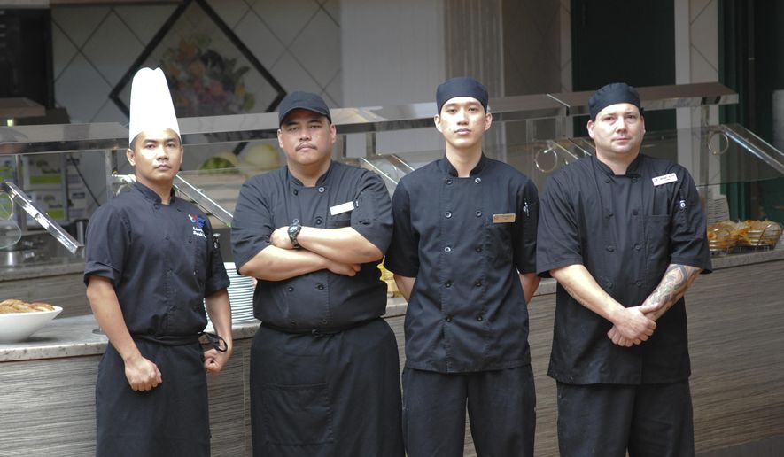 ADVANCE FOR USE SATURDAY OCT. 10 - In this photo taken Sept. 29, 2015, from left, Richen Granil, Skylight sous chef, Mike Sablan, Bistro cook, Tito Sablan and Anthony Bunten, Skylight chefs de partie. pose for a portrait in Hagatna, Guam. The four are former students of Guam Community College's Culinary Academy. Take a look inside almost any commercial kitchen in Guam, and it won’t be long before you spot someone who took culinary classes at Guam Community College. There are hundreds of them, employed at every level, doing every task required for any commercial food operation. (Jojo Santo Tomas/Pacific Daily News via AP) ALL GUAM, MICRONESIA MEDIA OUT, MANDATORY CREDIT