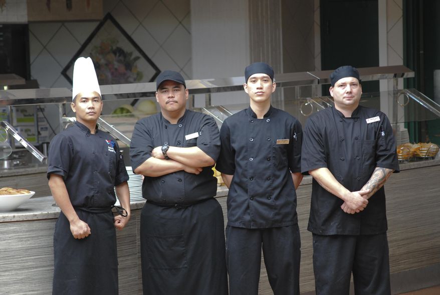ADVANCE FOR USE SATURDAY OCT. 10 - In this photo taken Sept. 29, 2015, from left, Richen Granil, Skylight sous chef, Mike Sablan, Bistro cook, Tito Sablan and Anthony Bunten, Skylight chefs de partie. pose for a portrait in Hagatna, Guam. The four are former students of Guam Community College's Culinary Academy. Take a look inside almost any commercial kitchen in Guam, and it won’t be long before you spot someone who took culinary classes at Guam Community College. There are hundreds of them, employed at every level, doing every task required for any commercial food operation. (Jojo Santo Tomas/Pacific Daily News via AP) ALL GUAM, MICRONESIA MEDIA OUT, MANDATORY CREDIT