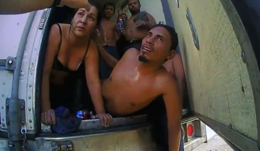 In this Sept. 18, 2015 image made from video released by the Frio County Sheriff's Department, immigrants listen to an law enforcement officer before exiting a truck after officers unlocked the rear doors in Moore, Texas. On Wednesday, Oct. 7, 2015, a federal grand jury indicted Drew Christopher Potter, 33, on charges of smuggling the 39 Central Americans. (Frio County Sherrif's Department via AP)