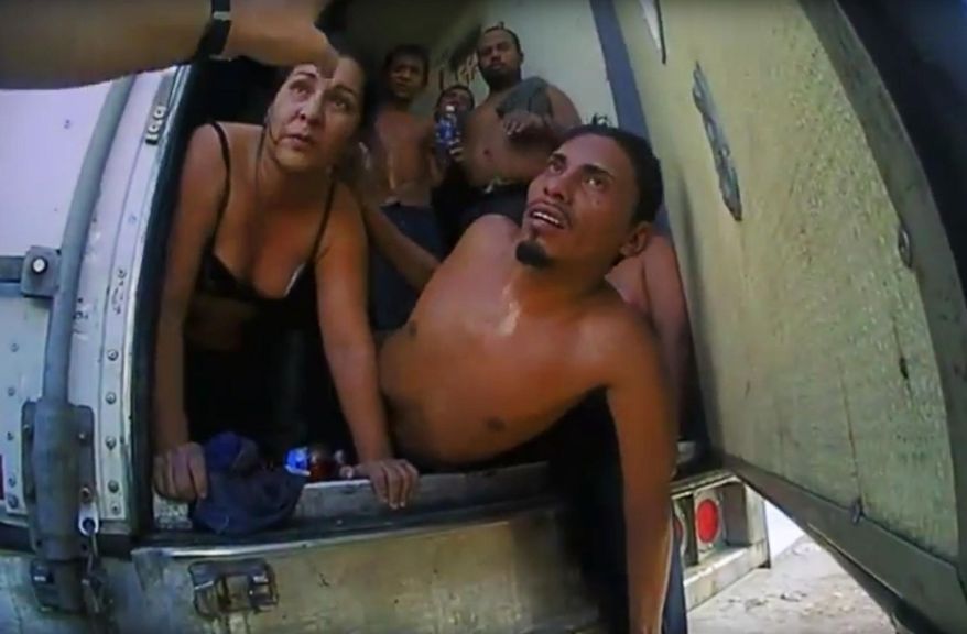In this Sept. 18, 2015 image made from video released by the Frio County Sheriff's Department, immigrants listen to an law enforcement officer before exiting a truck after officers unlocked the rear doors in Moore, Texas. On Wednesday, Oct. 7, 2015, a federal grand jury indicted Drew Christopher Potter, 33, on charges of smuggling the 39 Central Americans. (Frio County Sherrif's Department via AP)
