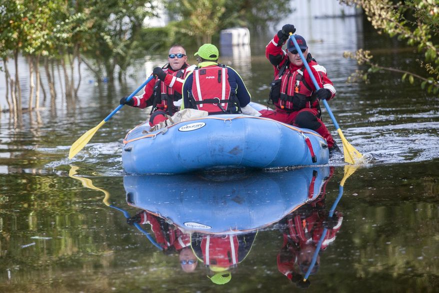 Firefighters evacuate Eliza Linen by boat from her home in the Dunbar Community of Georgetown, S.C., Friday, Oct. 9, 2015. A week after the heavy rains first began, some South Carolina residents are still evacuating and others are stacking up sandbags for more possible flooding even as the nation's top security official prepares to inspect the damage firsthand. (Jason Lee/The Sun News via AP)