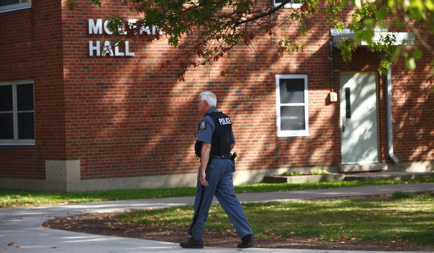 A New York State University police officer walks by McLean Hall at the State University of New York College at Brockport, N.Y., on Sept. 29, 2012. As colleges around the country review their safety plans in the wake of the latest campus shooting in Oregon, officials on New York’s public campuses say training and communication is key. Each campus in the State University of New York system has a full-time, armed police force and every campus is required to have a plan for active shooters. (Associated Press/Democrat &amp;amp; Chronicle, Marie De Jesus) **FILE**