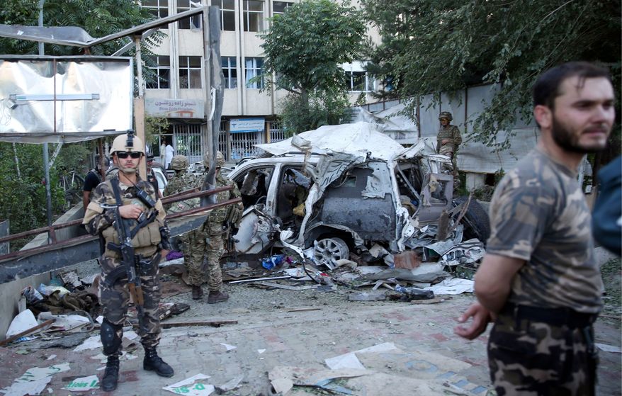 Afghan security forces and British soldiers inspect the site of a suicide attack in the heart of Kabul, Afghanistan. Loyalists of the Islamic State group are making inroads into Afghanistan, with homegrown militants claiming allegiance to the Islamic State as it controls territory in some parts of the country. (Associated Press)