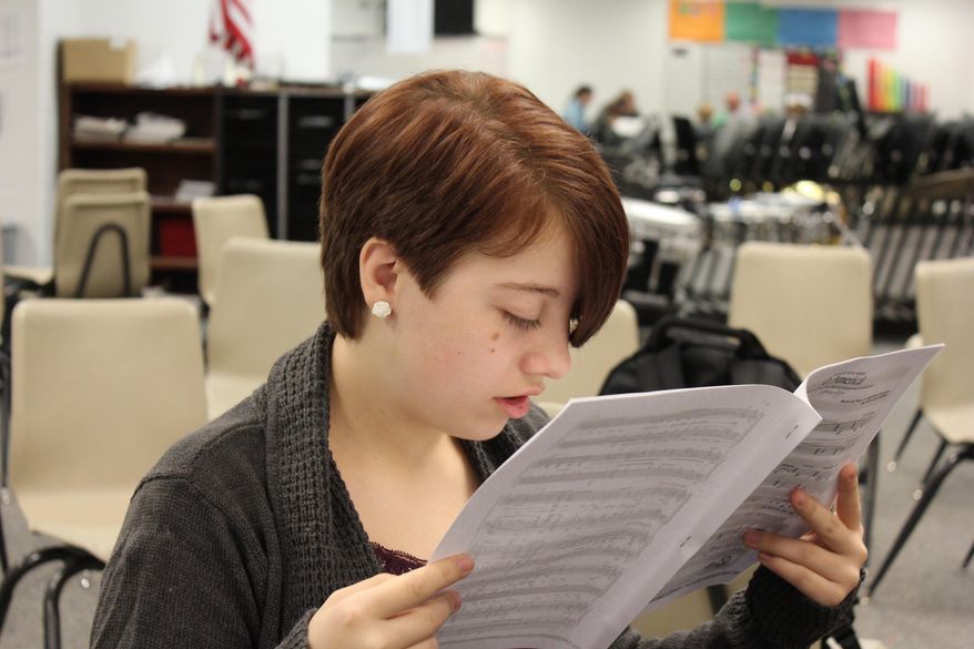 ADVANCE FOR THE WEEKEND OF OCT. 10-11 AND THEREAFTER. - In a Sept. 24, 2015 photo, Kayla Neeley reads sheet music during choir at Humphrey High School. Kayla was born with primary congenital glaucoma, which affects her vision. To read she has to hold the subject just inches from her face. It has not held her back; the 17-year-old senior is a semifinalist for the National Merit Scholarship. (Patrick Murphy/The Norfolk Daily News via AP) MANDATORY CREDIT