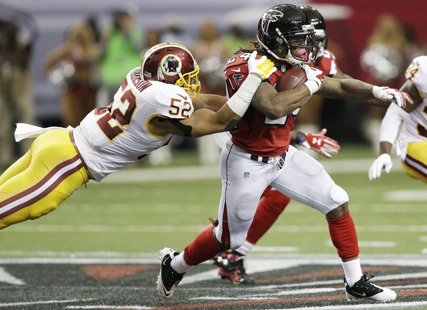 Atlanta Falcons running back Devonta Freeman (24) pulls Washington Redskins inside linebacker Keenan Robinson (52) during the second half of an NFL football game, Sunday, Oct. 11, 2015, in Atlanta. (AP Photo/Brynn Anderson)