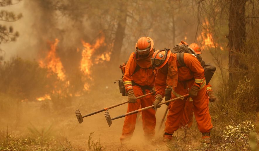 A California Department of Corrections and Rehabilitation inmate work crew builds a containment line ahead of flames from a fire near Sheep Ranch, Calif., in this Sept. 12, 2015, file photo. (AP Photo/Rich Pedroncelli, File)