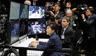 South Korean President Park Geun-hye operates a robotic arm during a tour of projects and programs that are underway at the agency&#39;s Goddard Space Flight Center, Wednesday, Oct. 14, 2015, in Greenbelt, Md. (AP Photo/Patrick Semansky)