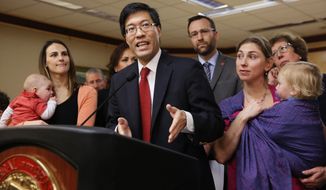 In this Feb. 4, 2015, file photo, state Sen. Richard Pan, D-Sacramento, center, accompanied co-author Ben Allen, D-Santa Monica, background, and concerned mothers and their children, answers a question about their proposed legislation requiring parents to vaccinate all school children, during a news conference in Sacramento, Calif. (AP Photo/Rich Pedroncelli, File)