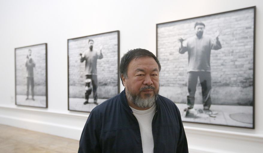FILE - In this Sept. 15, 2015 file photo, Chinese artist Ai Weiwei poses for photographers with one of his pieces at his exhibition at the Royal Academy of Arts in London. Ai is working on a currently untitled memoir. The Penguin Random House division Crown announced Wednesday, Oct. 14, 2015, that it would release the book in the spring of 2017. (AP Photo/Frank Augstein, File)