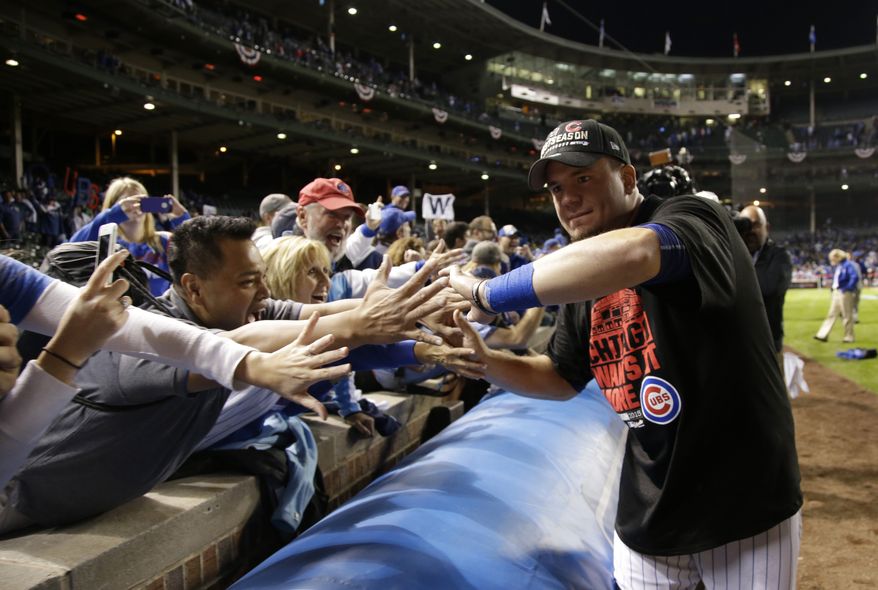 Chicago Cubs left fielder Kyle Schwarber gives high-fives to fans after the Cubs won 6-4 in Game 4 in baseball's National League Division Series against the St. Louis Cardinals, Tuesday, Oct. 13, 2015, in Chicago. (AP Photo/Nam Y. Huh)