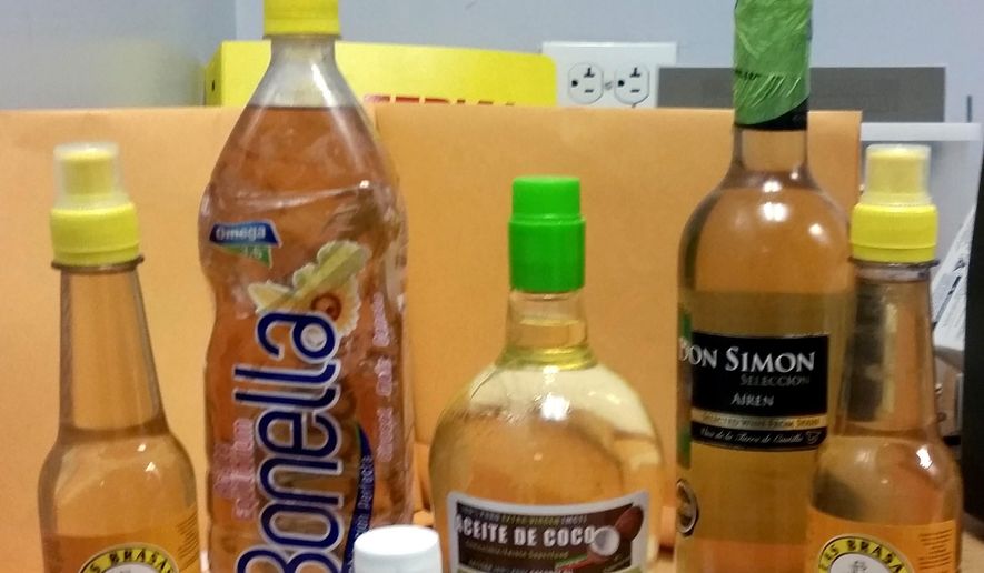 In this Oct. 5, 2015 photo provided U.S. Customs and Border Protection, bottles labeled oil and vinegar that contain liquid cocaine sit on a table in at private search room at New York’s John F. Kennedy International Airport. Law enforcement officials say a passenger who flew into the airport had the bottles stored in his luggage. (U.S. Customs and Border Protection via AP)