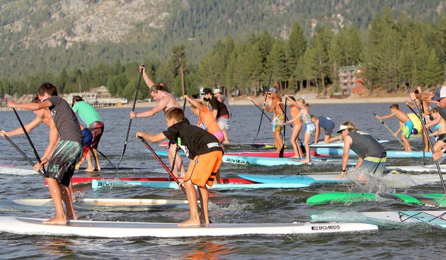In this undated photo, paddlers participate in South Tahoe Standup Paddle&#x27;s summer SUP Series on Lake Tahoe. Increased summer events and more resort offerings have been among the credits for higher summer lodging occupancy in western mountain towns from Colorado to California. (Anthony Gentile/The Tahoe Tribune via AP) MANDATORY CREDIT