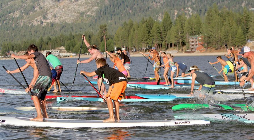 In this undated photo, paddlers participate in South Tahoe Standup Paddle's summer SUP Series on Lake Tahoe. Increased summer events and more resort offerings have been among the credits for higher summer lodging occupancy in western mountain towns from Colorado to California. (Anthony Gentile/The Tahoe Tribune via AP) MANDATORY CREDIT