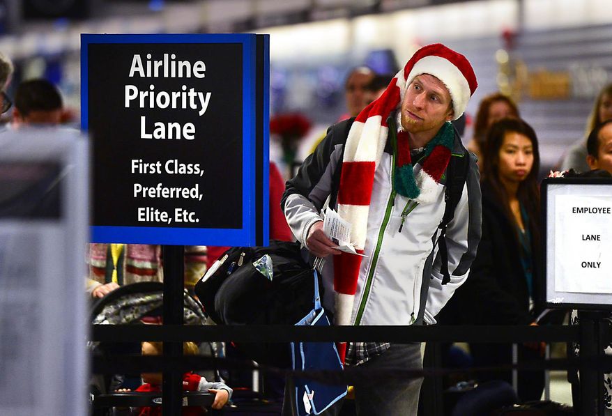 FILE - In this Dec. 24, 2014 file photo, Amos Darnell looks for a shorter line at the security checkpoint at Charlotte Douglas International Airport in Charlotte, N.C. Holiday travelers may find a little something extra in their stocking _ airfares should be a bit lower than last year. (Todd Sumlin/The Charlotte Observer via AP, File) MAGS OUT; TV OUT; MANDATORY CREDIT