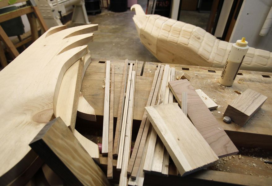 This Oct. 1, 2015 photo shows pieces of wood that are in process of being shaped into an eagle for a coffin by Eric Adjetey Anang, artist in residence at UW-Madison art department, in the Humanities Building in Madison, Wis. Anang spends much of the year away from his Ghana workshop, working at universities in the United States. (Michelle Stocker/The Capital Times via AP) MANDATORY CREDIT