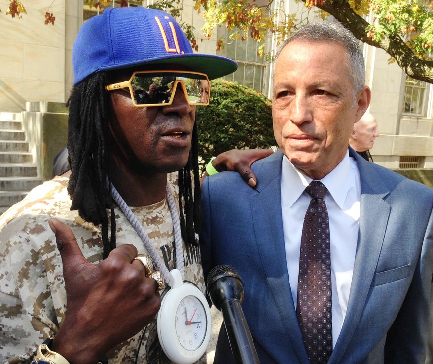 Entertainer Flavor Flav, left, standing with attorney Todd Greenberg, speaks with reporters after pleading guilty to one count of aggravated unlicensed operation of a motor vehicle, Tuesday, Oct. 13, 2015, in Mineola, N.Y. Flav, whose real name is William Drayton, Jr., was arrested in January 2014 while racing to his mother's funeral on Long Island. (AP Photo/Frank Eltman)