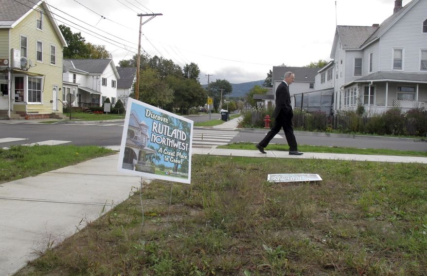 Rutland Police Cmdr. Scott Tucker walks at the corner of Library Avenue and Baxter Street in Rutland, Vt., in this Oct. 1, 2015, file photo. A decrepit building at the corner in the neighborhood was recently torn down so the lot could be turned into a park. (AP Photo/Wilson Ring)