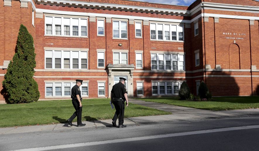 Police walk outside the Word of Life church on Thursday, Oct. 15, 2015, in New Hartford, N.Y. Bruce and Deborah Leonard have been charged in the beating death of their son, Lucas, and the severe beating of his 17-year-old brother, Christopher, inside the church on Sunday. Four other adults were charged with assault in the younger brother's beating, including Sarah Ferguson, 33, the victims' sister. (AP Photo/Mike Groll)