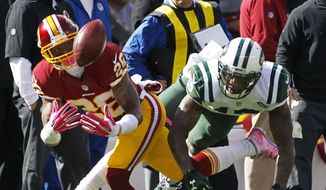 Washington Redskins cornerback Bashaud Breeland, left, makes an interception on a pass intended for New York Jets wide receiver Brandon Marshall during the first half of an NFL football game, Sunday, Oct. 18, 2015, in East Rutherford, N.J. (AP Photo/Gary Hershorn)