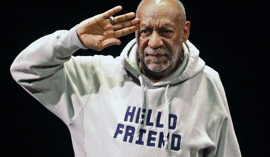 FILE - In this Jan. 17, 2015, file photo, comedian Bill Cosby salutes the crowd as he begins a performance at the Buell Theater in Denver. A year after allegations of sexual assault resurfaced and snowballed, women who’ve accused him of sexual assault are giving emotional interviews en masse, judges are ruling against him and colleges are continuing to revoke honorary degrees bestowed upon him when he was one of the country’s most admired entertainers. (AP Photo/Brennan Linsley, File)