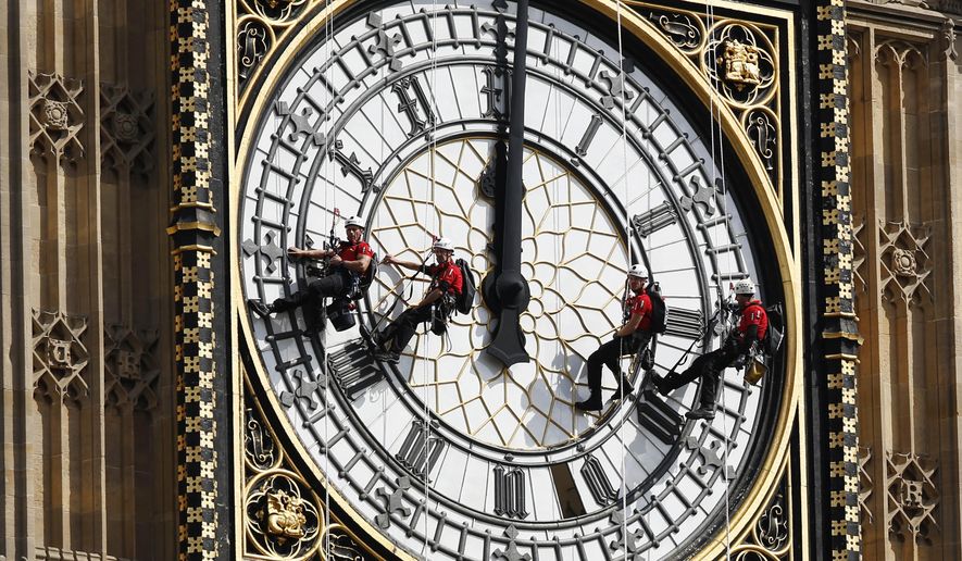 In this file photo dated  Monday, Aug. 18, 2014, workers abseil outside the clock face as they clean Big Ben&#x27;s clock tower of the Houses of Parliament in London.  According to reports published Sunday Oct. 18, 2015, the chimes of Big Ben may fall silent for many months as urgent repairs are carried out to the clock and the tower, which  must begin as soon as possible.(AP Photo/Sang Tan) ** FILE **