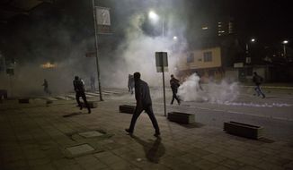 Protester run from tear gas in Kosovo capital Pristina as clashes broke out after the arrest of a prominent opposition politician Albin Kurti on Monday, Oct. 12, 2015. (AP Photo/Visar Kryeziu) ** FILE **