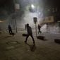 Protester run from tear gas in Kosovo capital Pristina as clashes broke out after the arrest of a prominent opposition politician Albin Kurti on Monday, Oct. 12, 2015. (AP Photo/Visar Kryeziu) ** FILE **