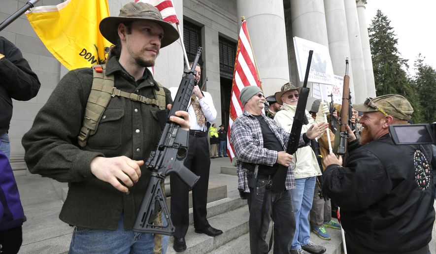 Gun owners display their weapons during a gun-rights rally on Jan. 15, 2015, at the Capitol in Olympia, Wash. The protesters were demonstrating against the state&#39;s Initiative 594, which requires - with only a few exceptions - background checks on all gun sales and transfers. (Associated Press)
