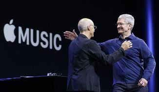In this June 8, 2015 file photo, Apple CEO Tim Cook, right, hugs Beats by Dre co-founder and Apple employee Jimmy Iovine at the Apple Worldwide Developers Conference in San Francisco when Apple announced Apple Music, an app that combines a 24-hour, seven-day live radio station called &quot;Beats&quot; with an on-demand music streaming service. (AP Photo/Jeff Chiu, File)