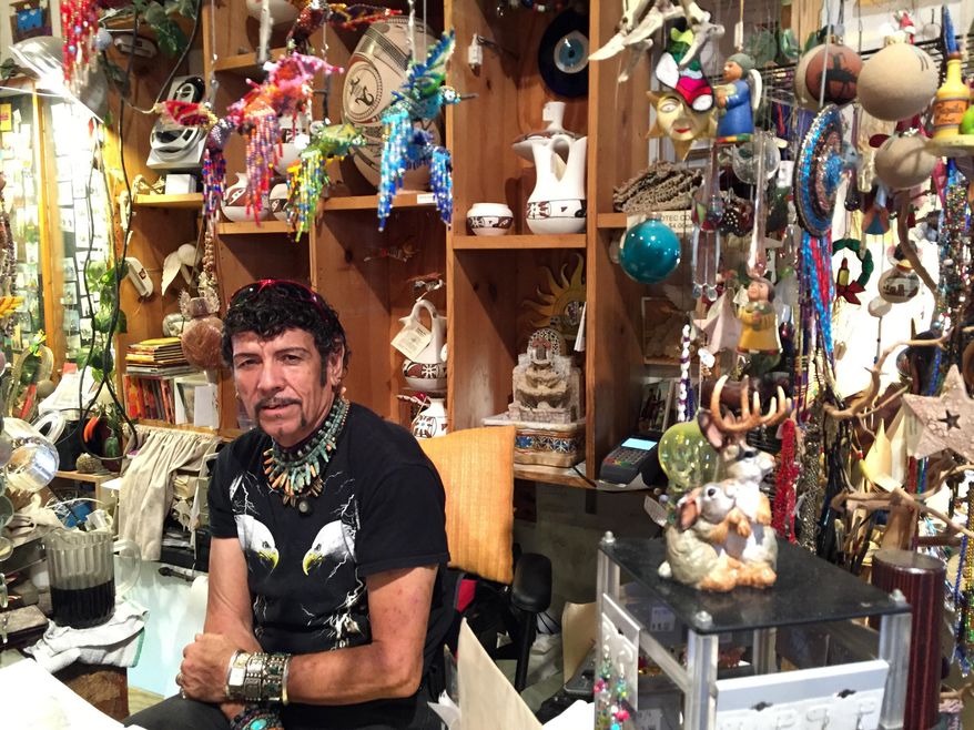 This Oct. 1, 2015 photo shows Eddie Gallego behind the counter of his gift and craft shop, Tolteca Tlacuilo, in Tucson, Ariz. The shop is located at Old Town Artisans, a restored 19th century marketplace in Tucson's El Presidio historic district. The Presidio is one of several distinct areas downtown that have recently been revitalized and that can make for an afternoon of shopping, dining and sightseeing. (AP Photo/Beth J. Harpaz)