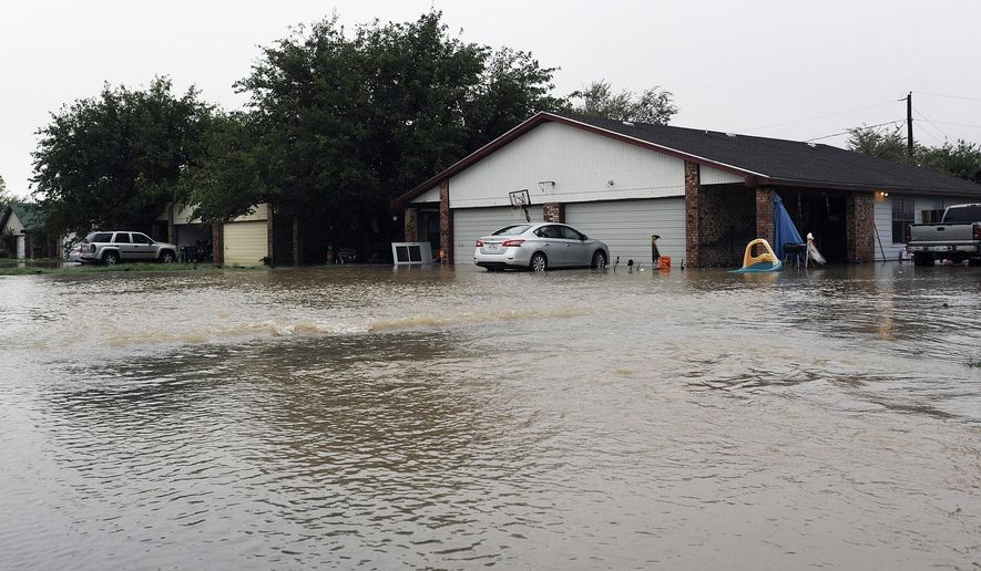 Water flows into a neighborhood Thursday, Oct. 22, 2015, in Midland County, Texas following heavy rains overnight. One home owner said he had water in his garage and his neighbor had water in his house. (Mark Sterkel/Odessa American via AP)