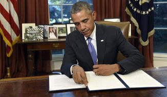President Barack Obama vetoes the National Defense Authorization Act (NDAA), Thursday, Oct. 22, 2015, in the Oval Office of the White House in Washington. The president vetoed the sweeping $612 billion defense policy bill, citing objections over how the measure is funded. (AP Photo/Susan Walsh)
