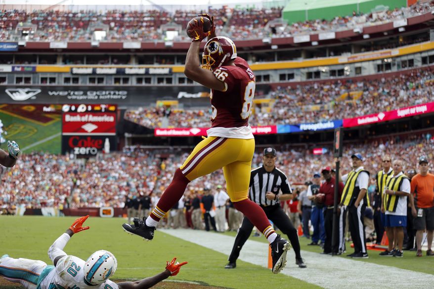 Washington Redskins tight end Jordan Reed (86) catches a touchdown pass over Miami Dolphins strong safety Reshad Jones (20) during the first half of an NFL football game Sunday, Sept. 13, 2015, in Landover, Md. (AP Photo/Patrick Semansky)