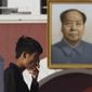 A man smokes near a portrait of late Chinese leader Mao Zedong hung on a replica of the Tiananmen Gate in Yinchuan in northwestern China&#39;s Ningxia Hui autonomous region on Thursday, Oct. 8, 2015.  Research published in the medical journal The Lancet says one in three of all the young men in China are likely to die from tobacco, but that the number can fall if the men quit smoking. (AP Photo/Ng Han Guan)