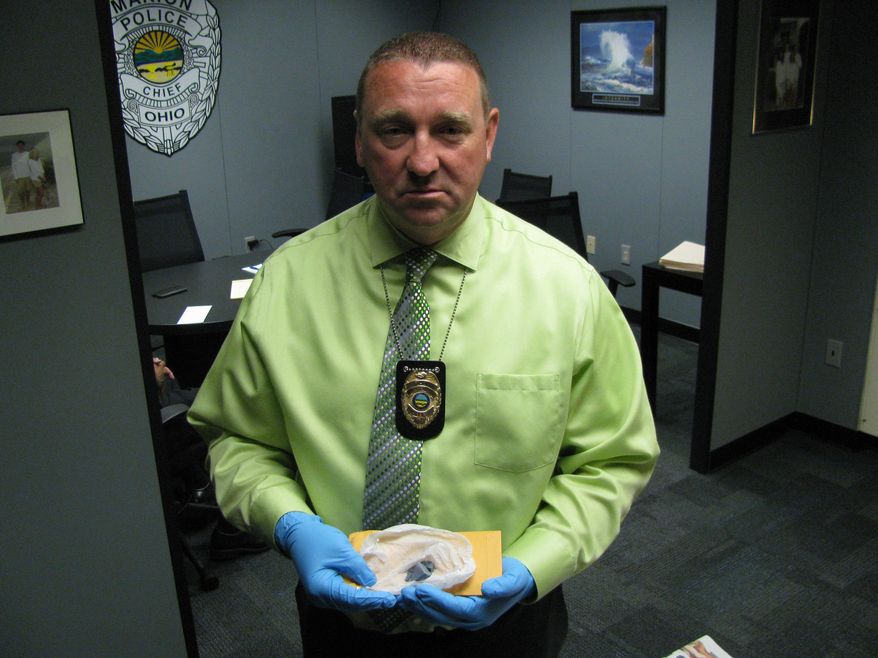 FILE - In this June 1, 2015, file photo, Bill Collins, police chief in Marion, Ohio, holds "blue drop" heroin laced with the painkiller fentanyl, which officials believe led to more than 30 overdoses and two deaths in the city in late May. At the request of the Ohio Department of Health, researchers from the Centers for Disease Control and Prevention plan to arrive in the state Monday, Oct. 26, 2015, to help find solutions to a wave of deaths attributed to fentanyl-laced heroin. (AP Photo/Mitch Stacy, File)