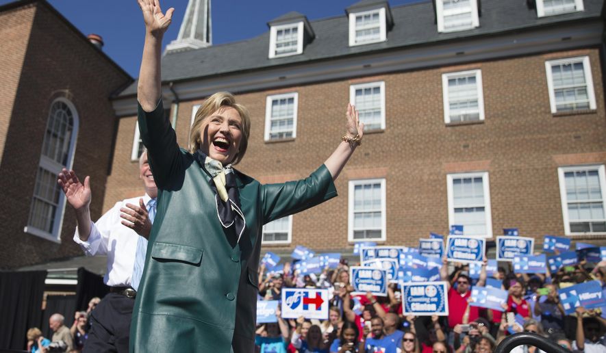 Democratic presidential candidate, former Secretary of State Hillary Rodham Clinton, accompanied by Virginia Gov. Terry McAuliffe, smiles and waves as she arrive for a campaign rally, Friday, Oct. 23, 2015, in Alexandria, Va. (AP Photo/Evan Vucci)