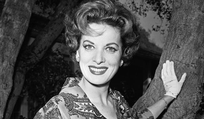 This Jan. 19, 1960, file photo shows movie actress Maureen O&#x27;Hara photographed in her front yard in Los Angeles. (AP Photo/Harold Filan, File)