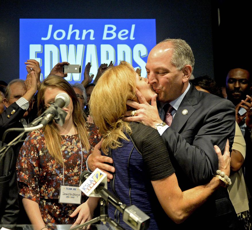Democrat John Bel Edwards gives his wife, Donna, a congratulatory kiss before addressing the crowd Saturday, Oct. 24, 2015, in downtown Baton Rouge, La. Edwards faces Republican David Vitter in a runoff in the gubernatorial race. (Hilary Scheinuk/The Advocate via AP)