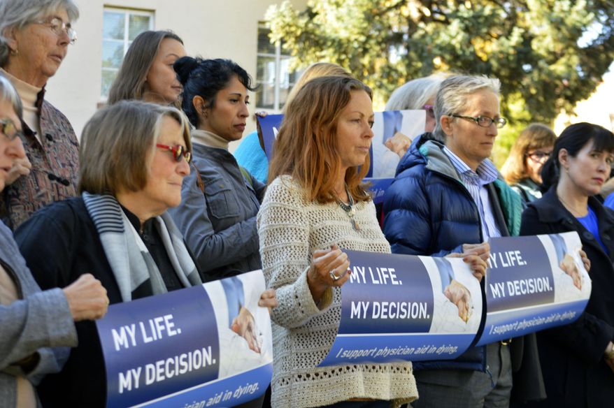 Right to die advocates rally on Monday, Oct. 26, 2015, outside the New Mexico Supreme Court in Santa Fe after a lawyer asked justices to allow terminally-ill patients to end their lives. Justices heard oral arguments Monday in a case that could overturn the state's assisted suicide law which allows prosecutors to criminally charge doctors who help terminally-ill patients end their lives. (AP Photo/Russell Contreras)